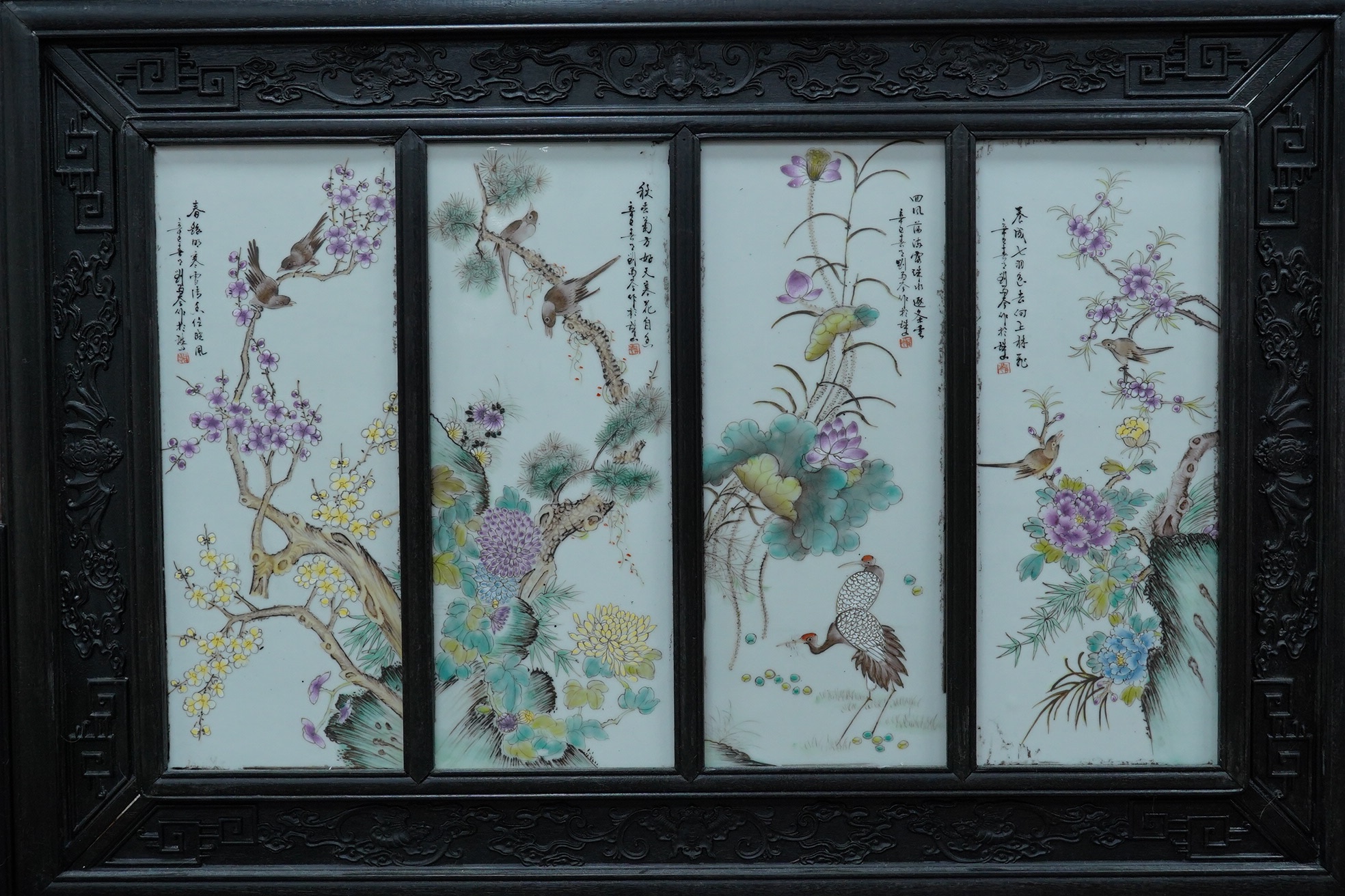 A Chinese hardwood screen with four porcelain panels. Condition - fair to good